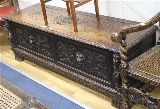 An early 18th century oak coffer, with later carved panelled front, W.159cm